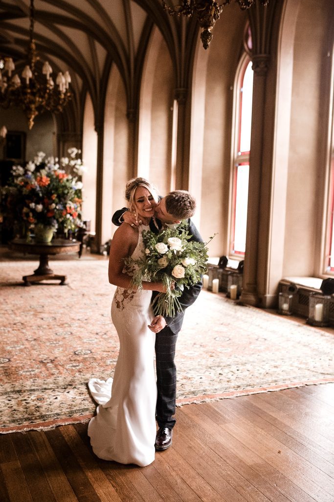 couple kissing at belvoir castle church wedding