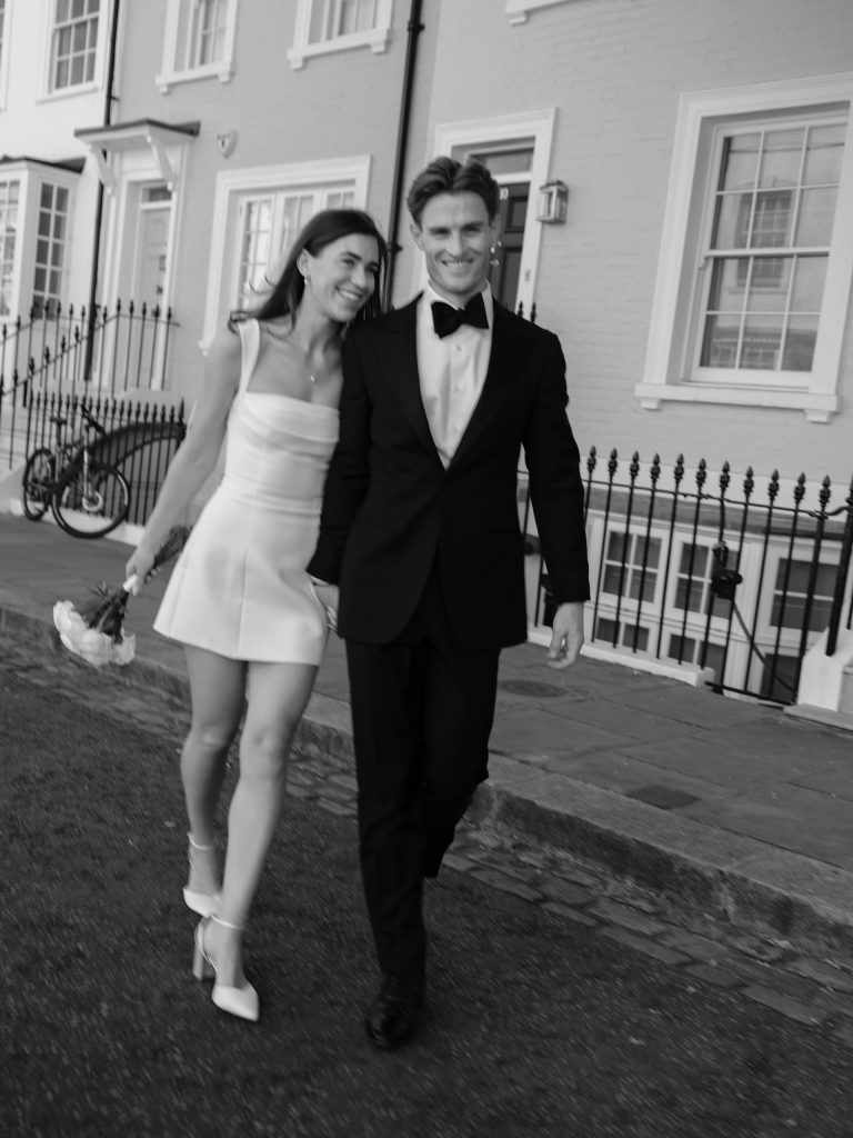 Newlyweds walking hand in hand through a London street after their intimate city wedding ceremony.